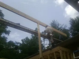 Carpenter setting a ridge beam over a new addition frame — Ice Dam Removal by Roofing Brothers in Greenleaf