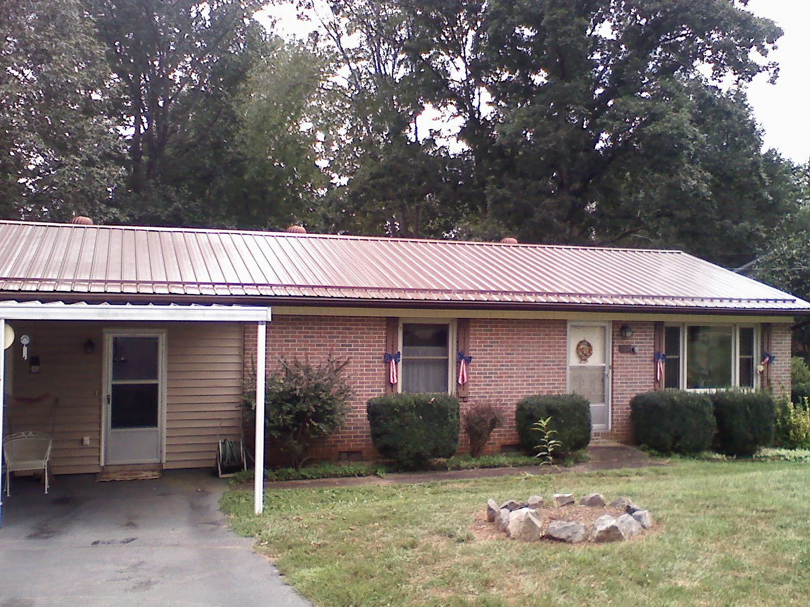 Bronze metal roof and carport on a brick ranch home — Roof Repair work by our crew in Greenleaf